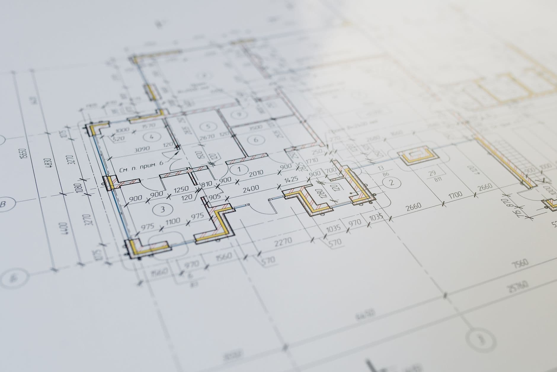 Detail van een bouwplan van een woning met maatlijnen en gemarkeerde muren op wit papier